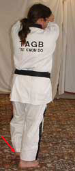 Turn head to look right towards A, pull front (left) leg back, raise arms facing outwards to chamber for middle block – right arm on the outside, facing outwards