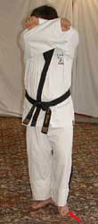 Turn head to look right towards B, pull front (left) leg back, raise arms to chamber for middle block