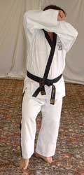 Turn head to look left towards A, pull front (right) foot back, raise hands to chamber for low block