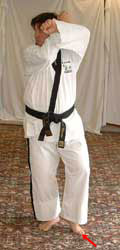 Turn head to look right towards B, pull front (left) leg back, raise arms to chamber for low block