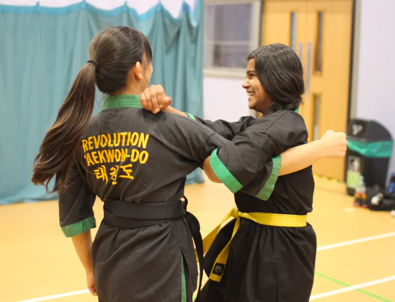A yellow belt woman practices an arm lock